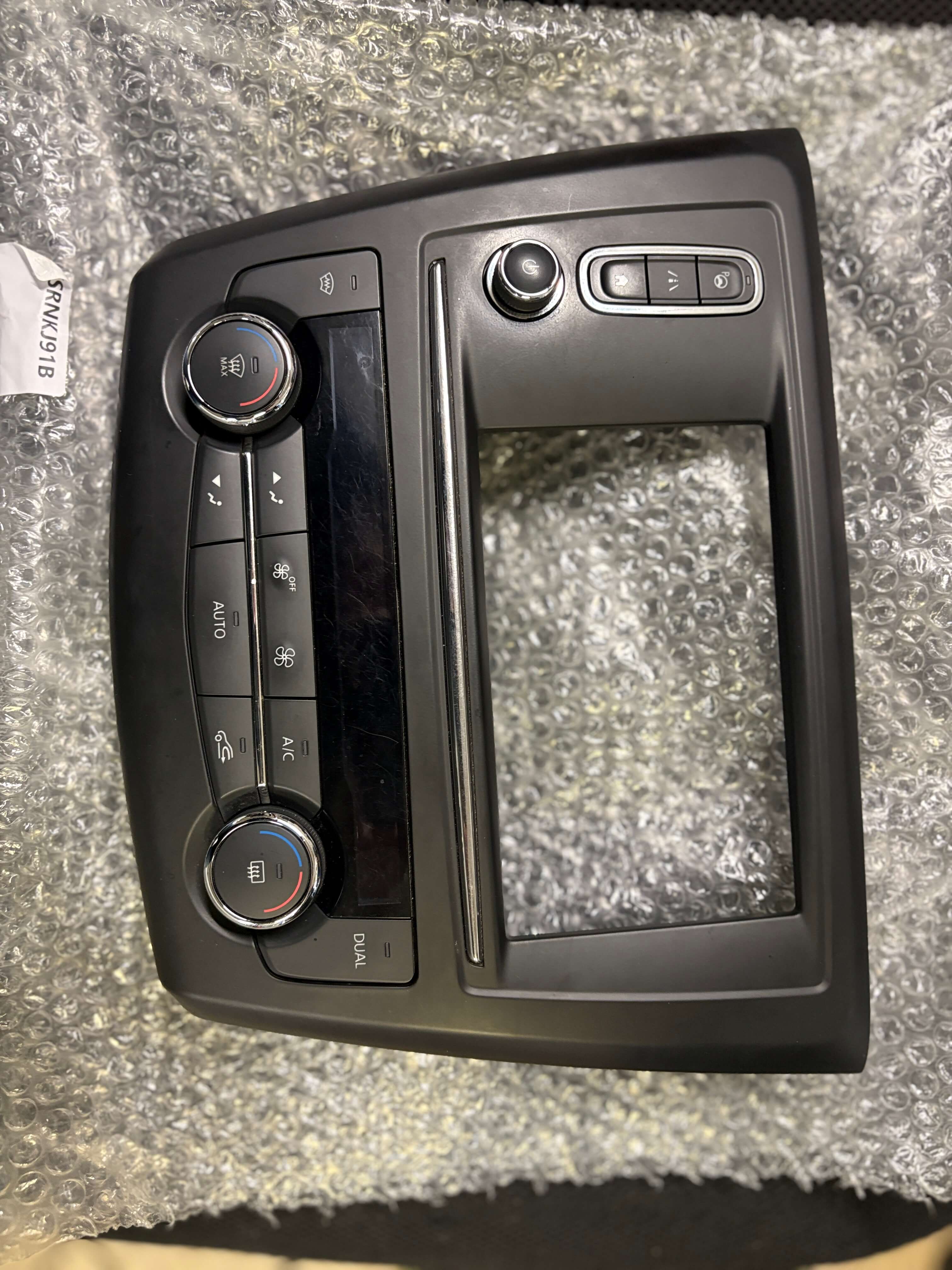 Demontovaný panel autorádia s ovládacím panelem klimatizace